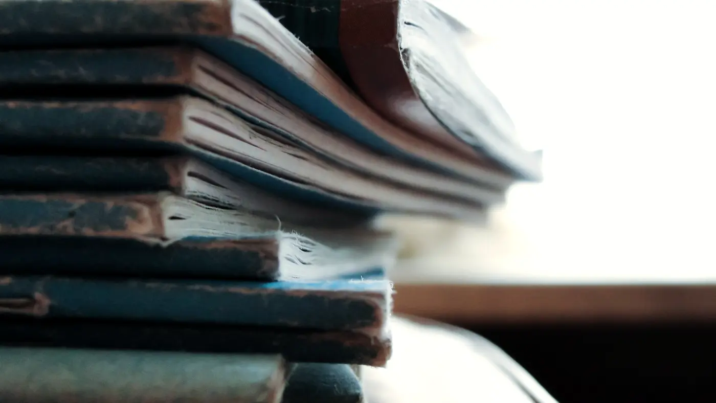 Close-up of a stack of worn old notebooks