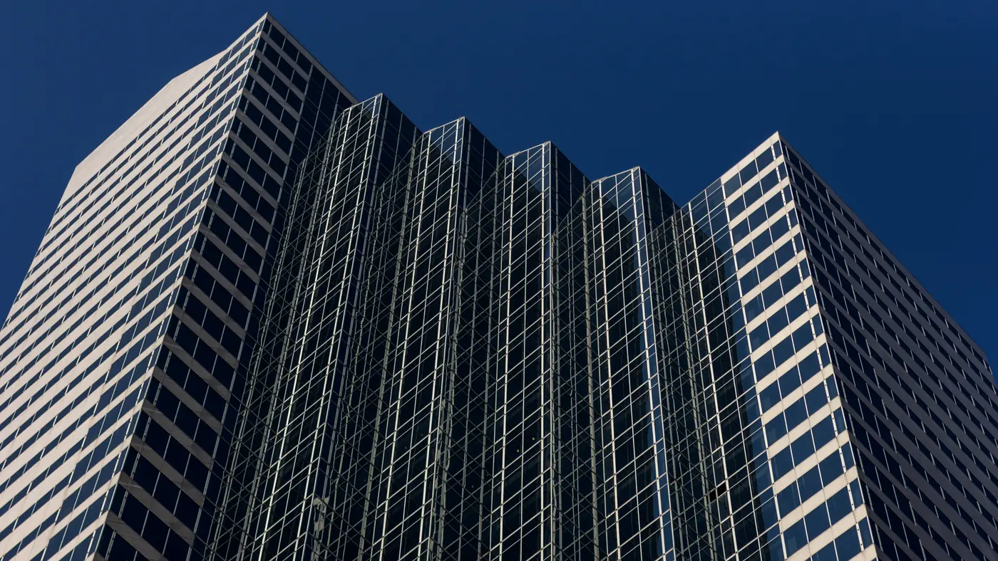 Glass office skyscraper against a deep blue sky