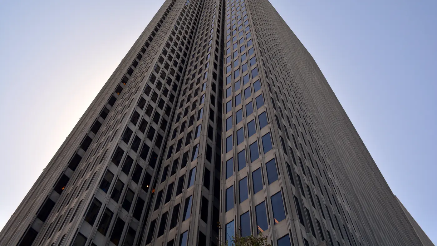 Glass and steel skyscraper seen from below against a blue sky
