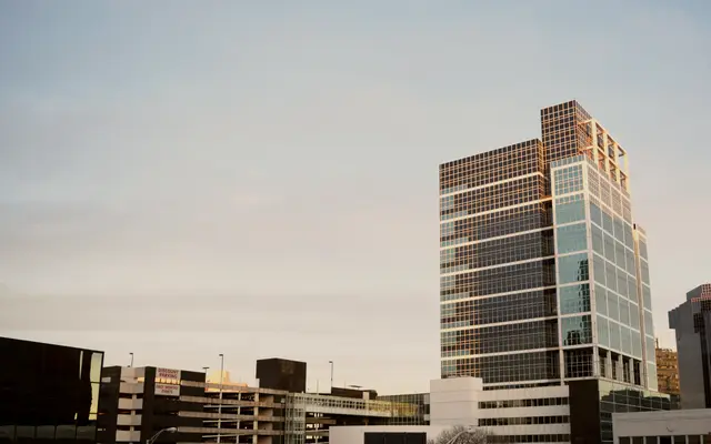 Glass office building rising above a low city skyline