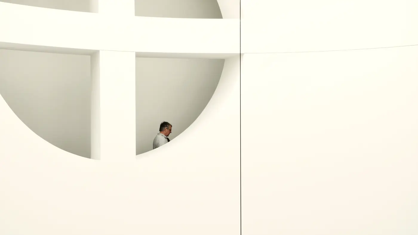 Man standing in a round opening of a white modern building