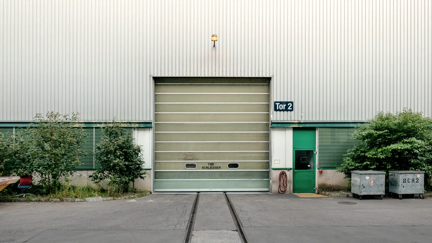 Warehouse loading bay with a roller door and rail tracks