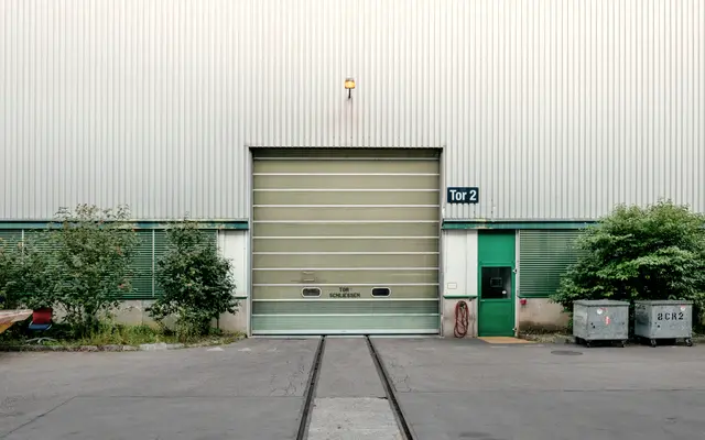 Warehouse loading bay with a roller door and rail tracks