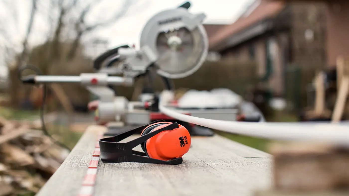 Mitre saw and ear defenders on an outdoor workbench