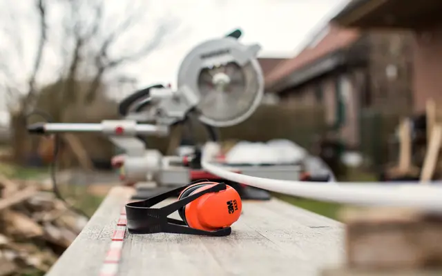 Mitre saw and ear defenders on an outdoor workbench