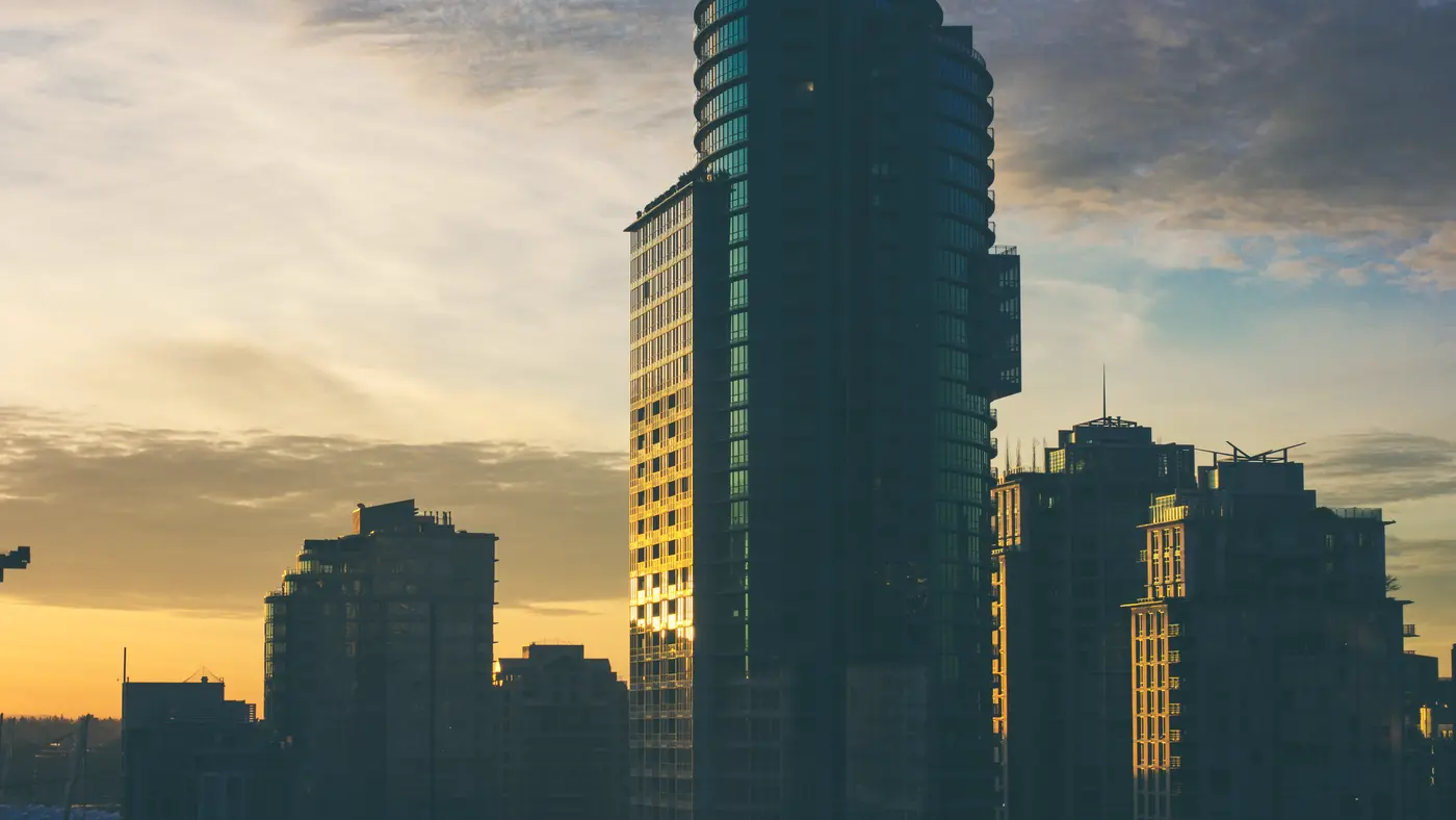 Glass office tower against a golden evening sky