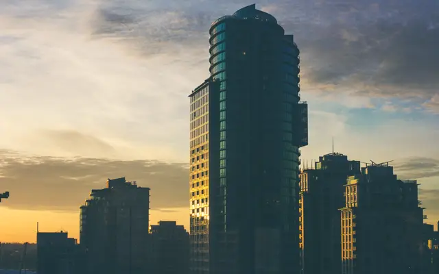 Glass office tower against a golden evening sky