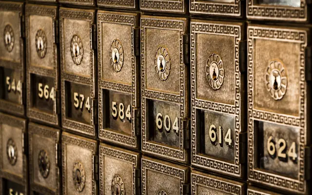 Rows of numbered vintage brass post office boxes