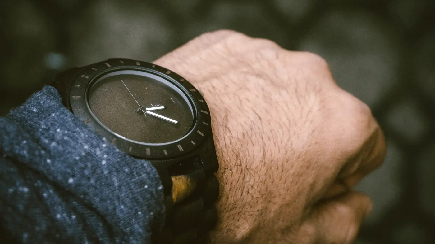 Close-up of a dark wooden wristwatch on a man's wrist