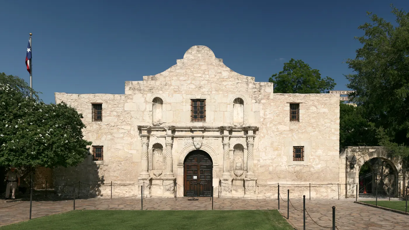 The Alamo's limestone facade in San Antonio under a blue sky