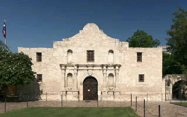 The Alamo's limestone facade in San Antonio under a blue sky