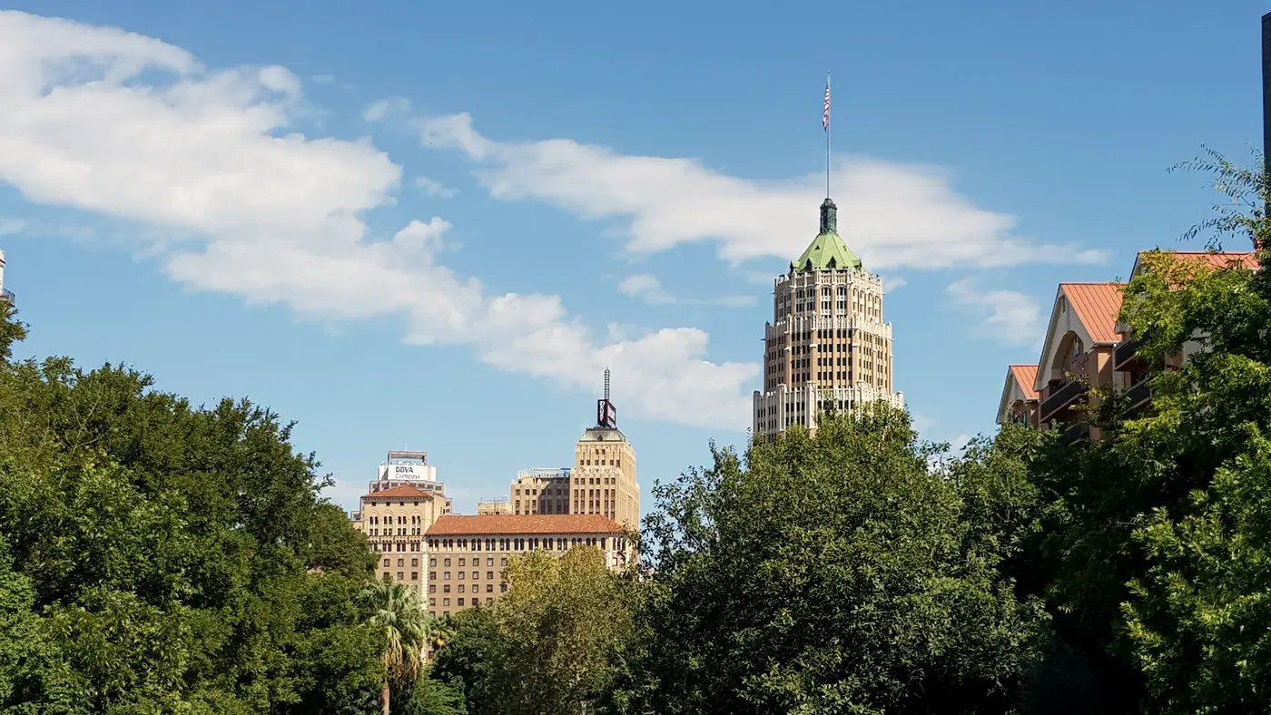 San Antonio River lined with trees below the historic Tower Life Building