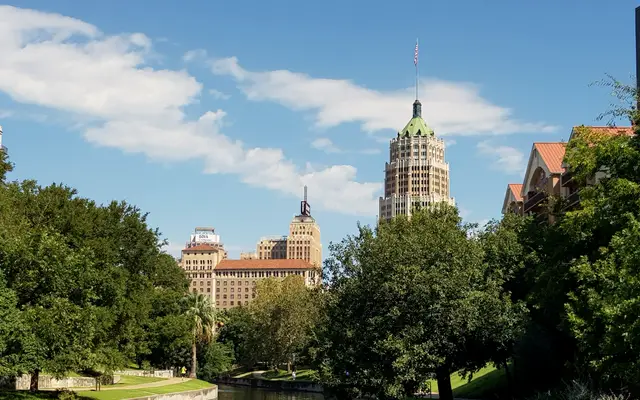 San Antonio River lined with trees below the historic Tower Life Building