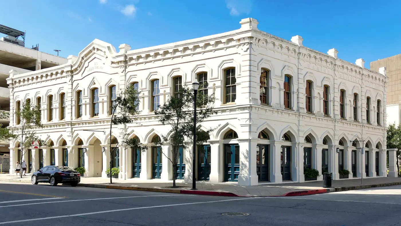 White historic Texas commercial building with arched windows on a corner