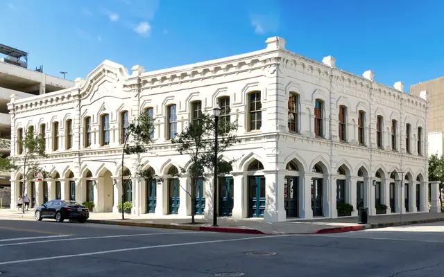 White historic Texas commercial building with arched windows on a corner