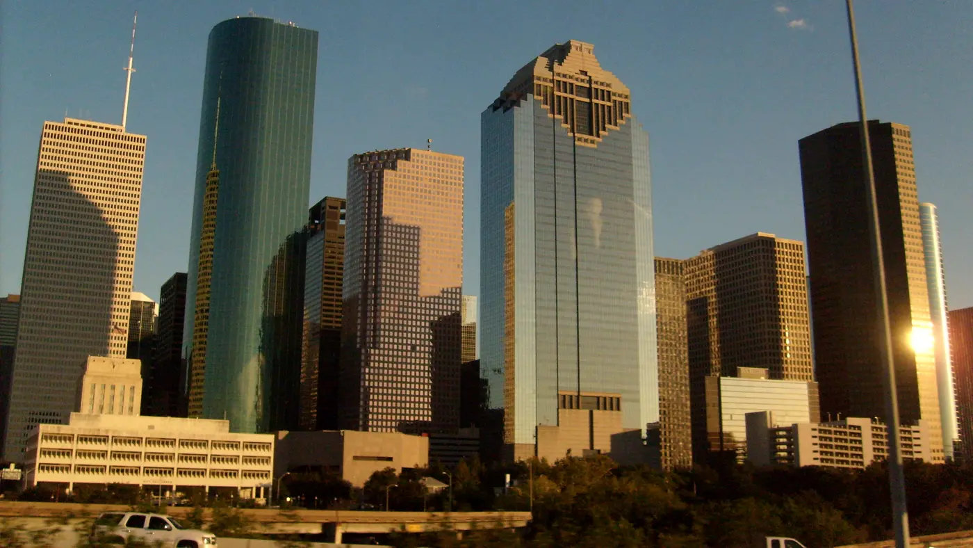 Downtown Houston glass towers lit by low golden afternoon sun