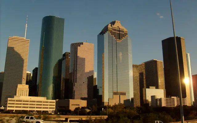 Downtown Houston glass towers lit by low golden afternoon sun