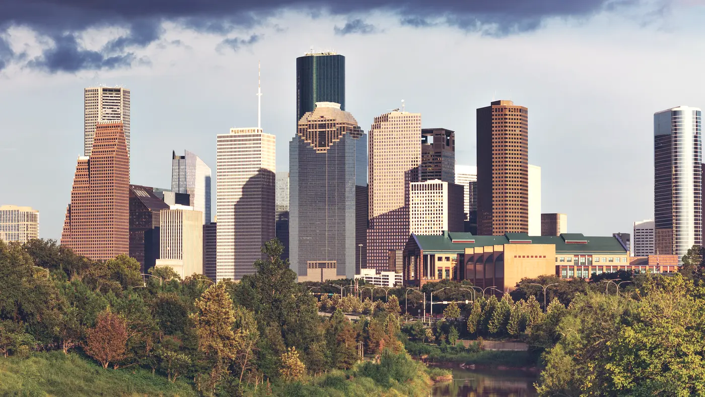 Houston skyline in warm light above a band of trees