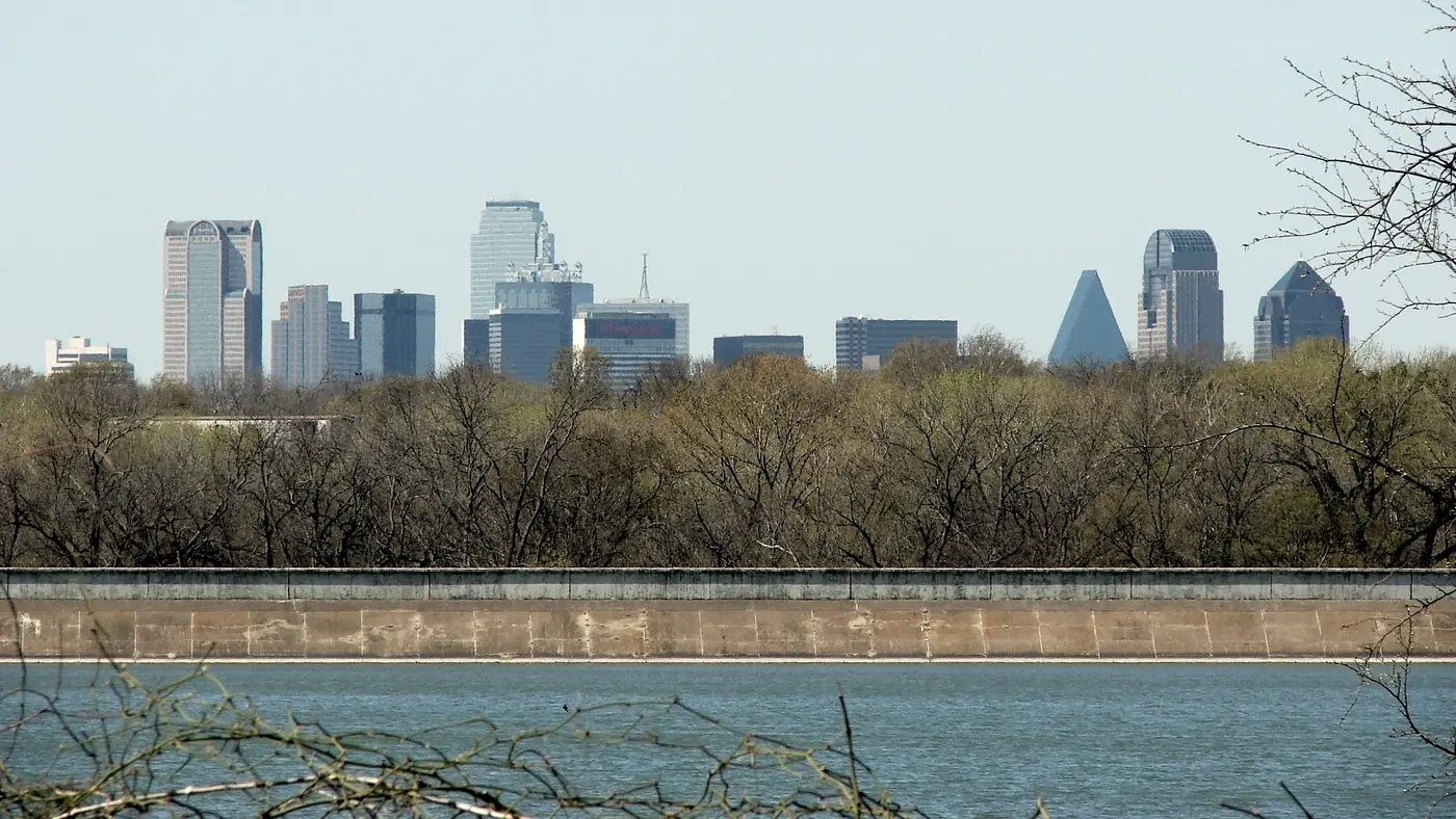 Dallas skyline above trees along the Trinity River levee