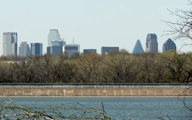 Dallas skyline above trees along the Trinity River levee